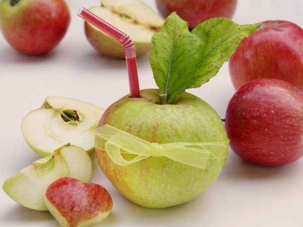Apfel mit Trinkhalm